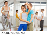 Happy preteen children practicing ballroom dances in pairs in training hall. Стоковое фото, фотограф Яков Филимонов / Фотобанк Лори
