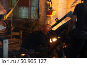 Workers at metallurgical plant pour molten metal from furnace into foundry ladle. Стоковое фото, фотограф Татьяна Яцевич / Фотобанк Лори