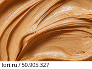 Creamy peanut butter spread swirl surface. Closeup, full frame. Crunchy Peanut butter background. American cuisine traditional product. Appetizing textured smears. Food paste from ground roasted nuts. Стоковое AI-изображение, AI-художник Марина Демидюк / Фотобанк Лори