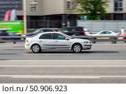 Facelifted Renault Laguna II at the city road in motion. Silver car driving along the street in city, side view. Accelerating with low-emission. Редакционное фото, фотограф Константин Григорьев / Фотобанк Лори
