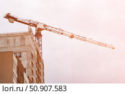 Construction crane towers over building under construction. Стоковое фото, фотограф Антон Вахрушев / Фотобанк Лори