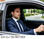Водитель в деловом костюме за рулём автомобиля. Стоковое AI-изображение, AI-художник Руслан Лесков / Фотобанк Лори
