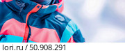 Close-up of a stylish winter jacket with bright color blocking for outdoor apparel promotion. Стоковое AI-изображение, AI-художник Данила Большаков / Фотобанк Лори