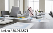 Modern boardroom prepared for corporate meeting with laptops showing financial data charts and business reports on dark wooden table before presentation. Стоковое AI-изображение, AI-художник Павел Муравьев / Фотобанк Лори