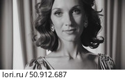 Sophisticated woman in monochrome, draped in elegant attire and accessories, standing near ornate curtains with timeless, glamorous elegance. Стоковое AI-видео, аниматор Данил Руденко / Фотобанк Лори