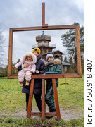 Family outing framed at a historic site, creating a portrait within a portrait during a visit. Музей-усадьба Ильи Ефимовича Репина "Здравнёво", Беларусь. Стоковое фото, фотограф Данила Большаков / Фотобанк Лори