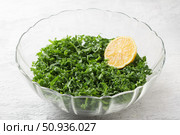 Chopped kale cabbage leaves with lemon in a transparent bowl on a light gray background. Стоковое фото, фотограф Ольга Лепёшкина / Фотобанк Лори