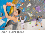 Young woman training rock climbing on climbing wall. Стоковое фото, фотограф Яков Филимонов / Фотобанк Лори
