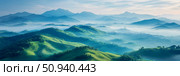 Scenic landscape of rolling hills and mountains shrouded in morning mist. Стоковое AI-изображение, AI-художник Данила Большаков / Фотобанк Лори
