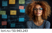 Portrait of a smart woman with afro looking at camera in front of a blackboard with colorful sticky notes in an office setting. Стоковое AI-изображение, AI-художник Данила Большаков / Фотобанк Лори