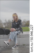 Young student sitting on a wall talking and gesturing. Стоковое видео, видеограф Константин Шишкин / Фотобанк Лори