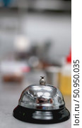 Gloved professional hand ringing service bell on stainless steel kitchen counter, signaling order completion or requesting urgent culinary assistance with metallic sound. Стоковое видео, видеограф Данил Руденко / Фотобанк Лори