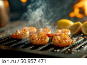Plump shrimp sizzle on an open grill, showcasing perfect grill marks. A smoky haze envelops them, highlighting the art of barbecuing seafood for a rich and flavorful experience. Стоковое AI-изображение, AI-художник Nart / Фотобанк Лори