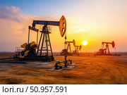 An expansive oil field teeming with nodding donkey pumpjacks. These mechanical giants tirelessly extract crude oil, showcasing the relentless pursuit of valuable natural resources. Стоковое AI-изображение, AI-художник Nart / Фотобанк Лори
