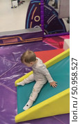 An adorable video of a toddler giggling with delight while sliding down a playground slide, ending with a heart-melting smile. This joyful childhood moment captures pure happiness, perfect for parenting content, children's product promotions, or lifestyle projects. Стоковое видео, видеограф Виктор Ветошкин / Фотобанк Лори