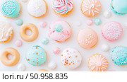 A delightful flat lay arrangement of charming pastel glazed donuts and delicate meringue kisses for a sweet celebration. Стоковое AI-изображение, AI-художник Данила Большаков / Фотобанк Лори