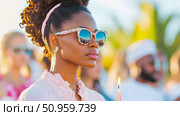 A graceful young woman with unique sunglasses and a lit candle, reflecting a communal gathering in sunlit ambiance, capturing a moment of serene celebration. Стоковое AI-изображение, AI-художник Данила Большаков / Фотобанк Лори