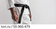 Martial artist in white gi with black belt close-up view. Стоковое AI-изображение, AI-художник Катерина Бондарец / Фотобанк Лори