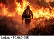 A photograph of a professional firefighter walking towards a raging forest fire. The image captures determination and courage in an extreme situation: a blazing background, thick smoke, sparks and flames surrounding a figure in protective gear holding an oxygen tank. This image conveys the drama, dedication and importance of firefighters in natural disasters. Стоковое AI-изображение, AI-художник Анна Кривицкая / Фотобанк Лори