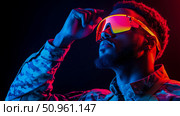 Futuristic Warrior: A portrait of a person wearing camouflage and hi-tech eyewear in neon light. Стоковое AI-изображение, AI-художник Данила Большаков / Фотобанк Лори
