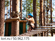Girl Navigates Rope Park Adventure in the Woods Under Clear Skies. Стоковое фото, фотограф Aleksandr Golubev / Фотобанк Лори