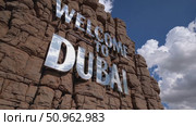 Metallic Welcome to Dubai letters mounted on rocky terrain, mirroring azure skies and billowing clouds with vibrant landscape perspective. Стоковое AI-видео, аниматор Данил Руденко / Фотобанк Лори