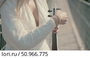 A young woman in a white dress tunes a white violin while standing in a bridge. Стоковое видео, видеограф Tatiana Malinsky / Фотобанк Лори