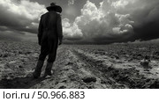 A lone figure in a cowboy hat stands in a vast, tilled field under a dramatic, stormy sky, evoking a sense of struggle and hope, conceptual art. Стоковое AI-изображение, AI-художник Данила Большаков / Фотобанк Лори