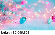Dreamy pastel pink and blue Christmas holiday decoration with sparkly ornaments, frosted pine branch, and enchanting string lights creating a magical festive ambiance. Стоковое AI-изображение, AI-художник Данила Большаков / Фотобанк Лори