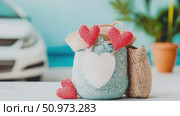 Handcrafted woven carryalls adorned with red knitted hearts and a prominent white heart accent, embodying affection for a serene getaway. Стоковое AI-видео, аниматор Данила Большаков / Фотобанк Лори