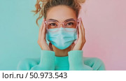 Modern depiction of a young female in spectacles and a face covering, showcasing personal safety against a lively dual-tone backdrop. Стоковое AI-видео, аниматор Данила Большаков / Фотобанк Лори