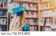 Young academic wearing a mortarboard, standing among blurred library shelves, representing education and scholarly endeavor. Стоковое AI-видео, аниматор Данила Большаков / Фотобанк Лори