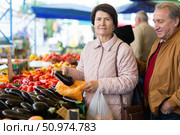 Aged man and woman customers buying vegetables in open-air market. Стоковое фото, фотограф Татьяна Яцевич / Фотобанк Лори