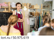Woman teacher at blackboard conducts theoretical lesson for sewing school children students. Стоковое фото, фотограф Яков Филимонов / Фотобанк Лори