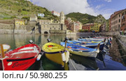 Colorful boats docked in Vernazza harbor with scenic buildings and hills around. Редакционное видео, видеограф Антон Гвоздиков / Фотобанк Лори