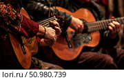 Two individuals are playing acoustic guitars in a cozy room, focusing on their music and enjoying the shared experience. Стоковое AI-изображение, AI-художник Данила Большаков / Фотобанк Лори