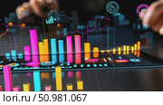 Analyzing data trends with colorful graphs and charts displayed on a digital tablet in a modern office environment. Стоковое AI-видео, аниматор Данила Большаков / Фотобанк Лори