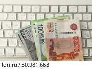 Купюры сто долларов, сто евро и пять тысяч рублей лежат на клавиатуре. Стоковое фото, фотограф Дмитрий Серегин / Фотобанк Лори