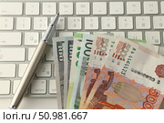 На белой клавиатуре лежат купюры сто долларов, сто евро и пять тысяч рублей. Стоковое фото, фотограф Дмитрий Серегин / Фотобанк Лори