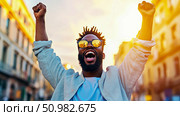 Triumphant Man in City at Sunset: Celebrating Success in Urban Setting. Стоковое AI-изображение, AI-художник Данила Большаков / Фотобанк Лори