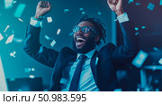 Enthusiastic African American man in business attire exulting in victory with raised fists and open mouth as confetti rains down. Стоковое AI-изображение, AI-художник Данила Большаков / Фотобанк Лори