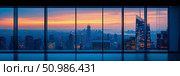 Panoramic cityscape at twilight from high-rise executive office window, showcasing vibrant sunset over sprawling metropolis with illuminated buildings and distant waterways. Стоковое AI-изображение, AI-художник Данила Большаков / Фотобанк Лори