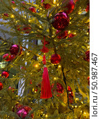 Red tassel and ornaments hanging on a tree with warm festive lights, celebrating Chinese New Year in Moscow. Редакционное фото, фотограф Софья Соломонова / Фотобанк Лори
