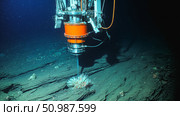 A deep sea mining robot operates on the ocean floor. It extracts minerals from the seabed, surrounded by marine life and sediment. Стоковое AI-изображение, AI-художник Евгения Пархоменко / Фотобанк Лори