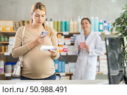 Pregnant woman buyer scans pills qr code with woman pharmacist. Стоковое фото, фотограф Яков Филимонов / Фотобанк Лори