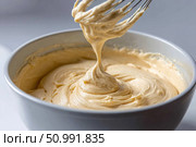 Whisk dripping cake batter into a mixing bowl, creating delicious desserts. Стоковое фото, фотограф Юрий Поздников / Фотобанк Лори