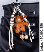 Close-up of a stylish leather bag accessory featuring a detailed leather bear charm no black  bag. Стоковое фото, фотограф Виталий Сова / Фотобанк Лори
