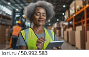 Warehouse worker reviews inventory using tablet in modern facility during day shift. Стоковое AI-видео, аниматор Сергей Толмачёв / Фотобанк Лори