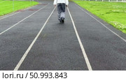 A girl walks on a treadmill at a stadium in the summer. Стоковое видео, видеограф Соболева Наталия / Фотобанк Лори
