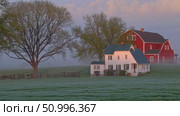 Foggy sunrise illuminating rustic red barn, white farmhouse, large tree silhouetted against misty agricultural landscape with soft morning light. Стоковое AI-видео, аниматор Данил Руденко / Фотобанк Лори